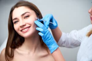 Woman smiling while receiving Belotero dermal filler injections for fine lines in Los Angeles, CA